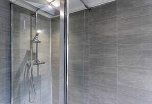 Een douchecabine met een handdouche en een douchekoof.