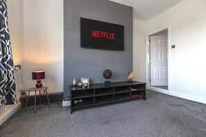 A modern living room with a flat-screen TV mounted on the wall, a black entertainment unit below, and a door to the right. - The Waltons – Ideal Durham Escape - Nature Lovers - Pass the Keys (New Brancepeth)