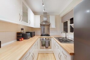 A modern kitchen with white cabinets, a stainless steel range hood, a built-in oven, and a sink. - Characterful 3 Bed | Sleeps 6 | Central Darlington - Pass the Keys (Darlington)