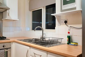 A kitchen with a stainless steel sink, a window, and a dish rack. - Characterful 3 Bed | Sleeps 6 | Central Darlington - Pass the Keys (Darlington)