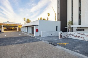 Ein Parkplatz mit einem Gebäude, auf dem 'MILKWOOD' steht, und einer überdachten Parkstruktur.
