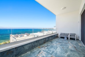 A balcony with a view of the sea, a seating area, and a modern architectural design. - Olymp Royal Palace - Ultra Luxury Beachfront House (Paphos)