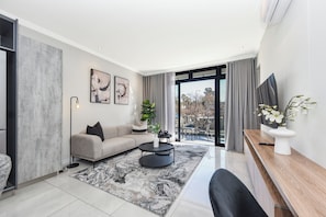 A modern living room with a sofa, coffee table, and artwork on the wall. - The Paramount | Contemporary Luxury (Johannesburg)