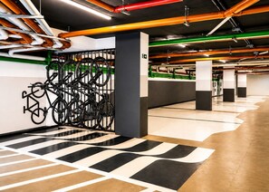 A modern indoor parking area with a bike rack, clean floors, and exposed pipes. - Breeze Residence 317 Beachfront Flat at Bessa (João Pessoa)