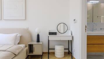 A modern bathroom with a glass shower enclosure, a white sink, and a mirror.