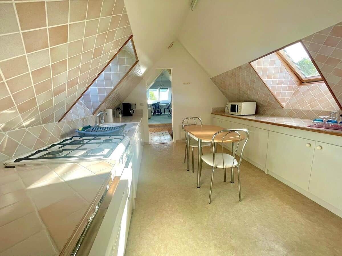 Een keuken met een eethoek, een magnetron en uitzicht door een dakraam.