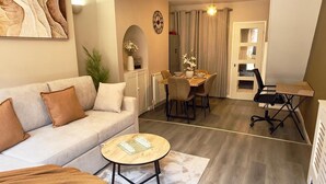 Una sala de estar con sofá, mesa de centro y comedor con mesa y sillas.