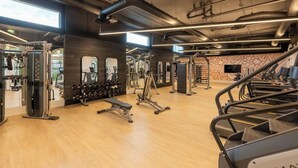 A gym with various exercise equipment, wooden flooring, and large windows allowing natural light. - Vibrant King 1B1B｜Pool & Spa｜Smart 4K TVs (Montclair)