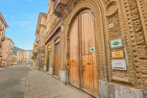 A building with large wooden doors and a sign indicating 'L'Opera' and 'Rooms.' - [RoomsCamera3] 5Terre-Near the station+A/C (La Spezia)
