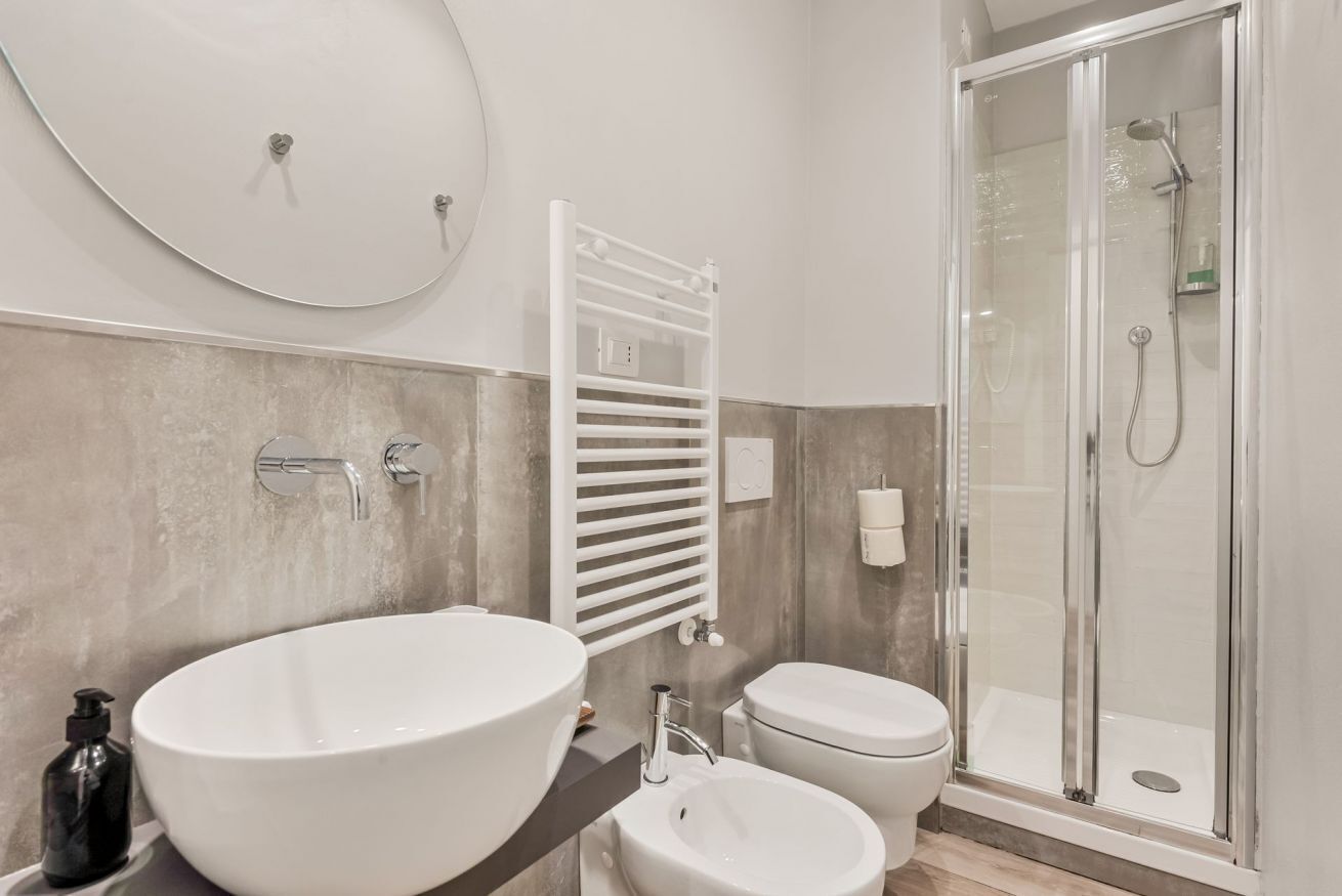 Une salle de bain moderne avec un grand lavabo ovale, des toilettes et une douche à parois de verre.