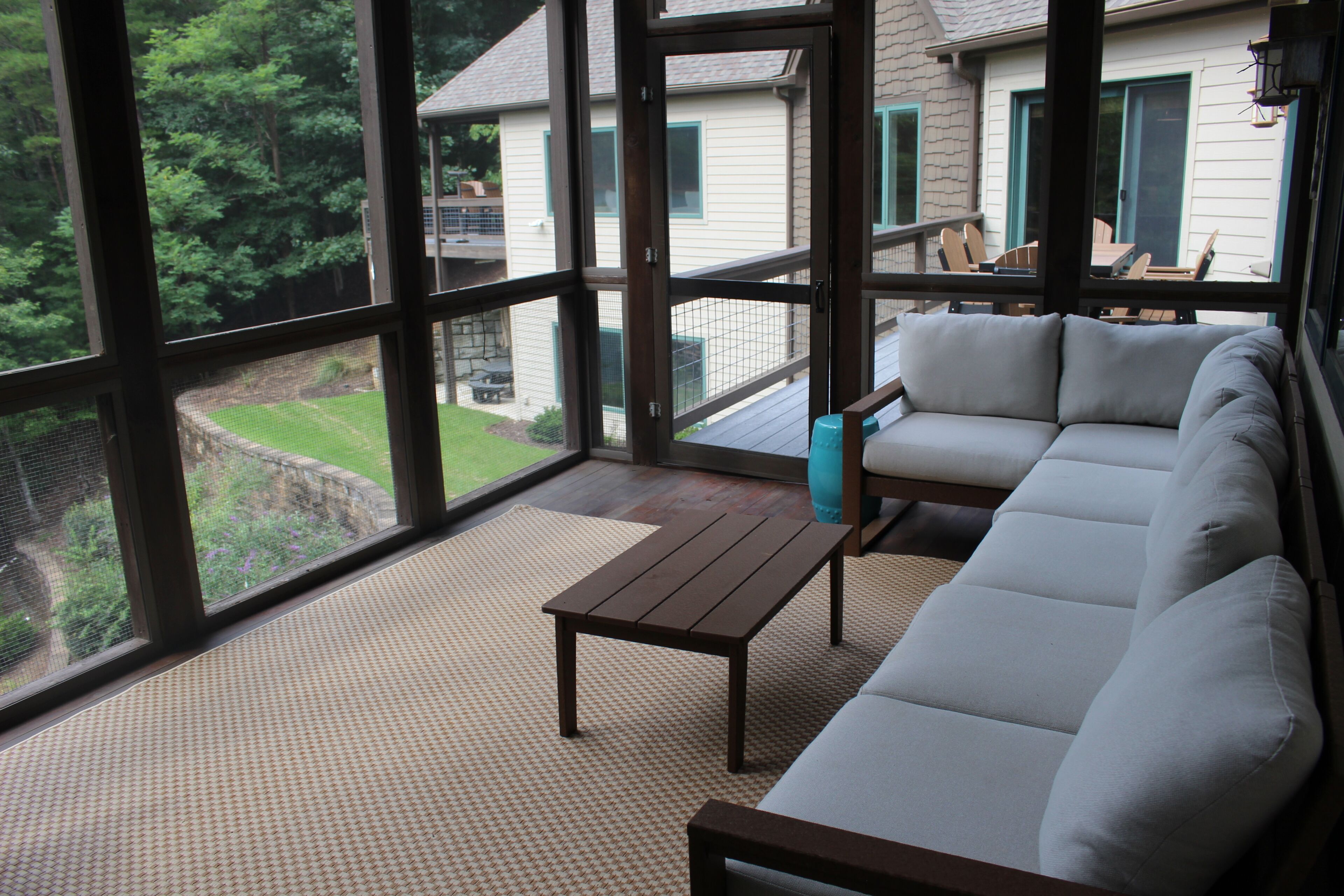 A room with a large window, a sofa, and a small table.
