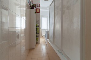 A narrow hallway with tiled walls, a tiled floor, and a door leading to a bathroom. - Cozy 45 sqm flat, perfect for 3 people, located on the 5th floor of a building with elevator.The property is situated in the Calvairate district, a residential area characterized by the green spaces of Piazza Insubria & Viale Molise.The Porta Romana dist (Milan)