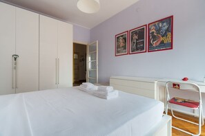 A bedroom with a bed, a wardrobe, a desk, and a chair. There are posters on the wall. - Cozy 45 sqm flat, perfect for 3 people, located on the 5th floor of a building with elevator.The property is situated in the Calvairate district, a residential area characterized by the green spaces of Piazza Insubria & Viale Molise.The Porta Romana dist (Milan)