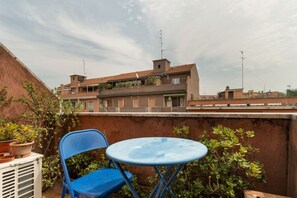 A blue chair and table on a rooftop terrace with a view of residential buildings. - Cozy 45 sqm flat, perfect for 3 people, located on the 5th floor of a building with elevator.The property is situated in the Calvairate district, a residential area characterized by the green spaces of Piazza Insubria & Viale Molise.The Porta Romana dist (Milan)