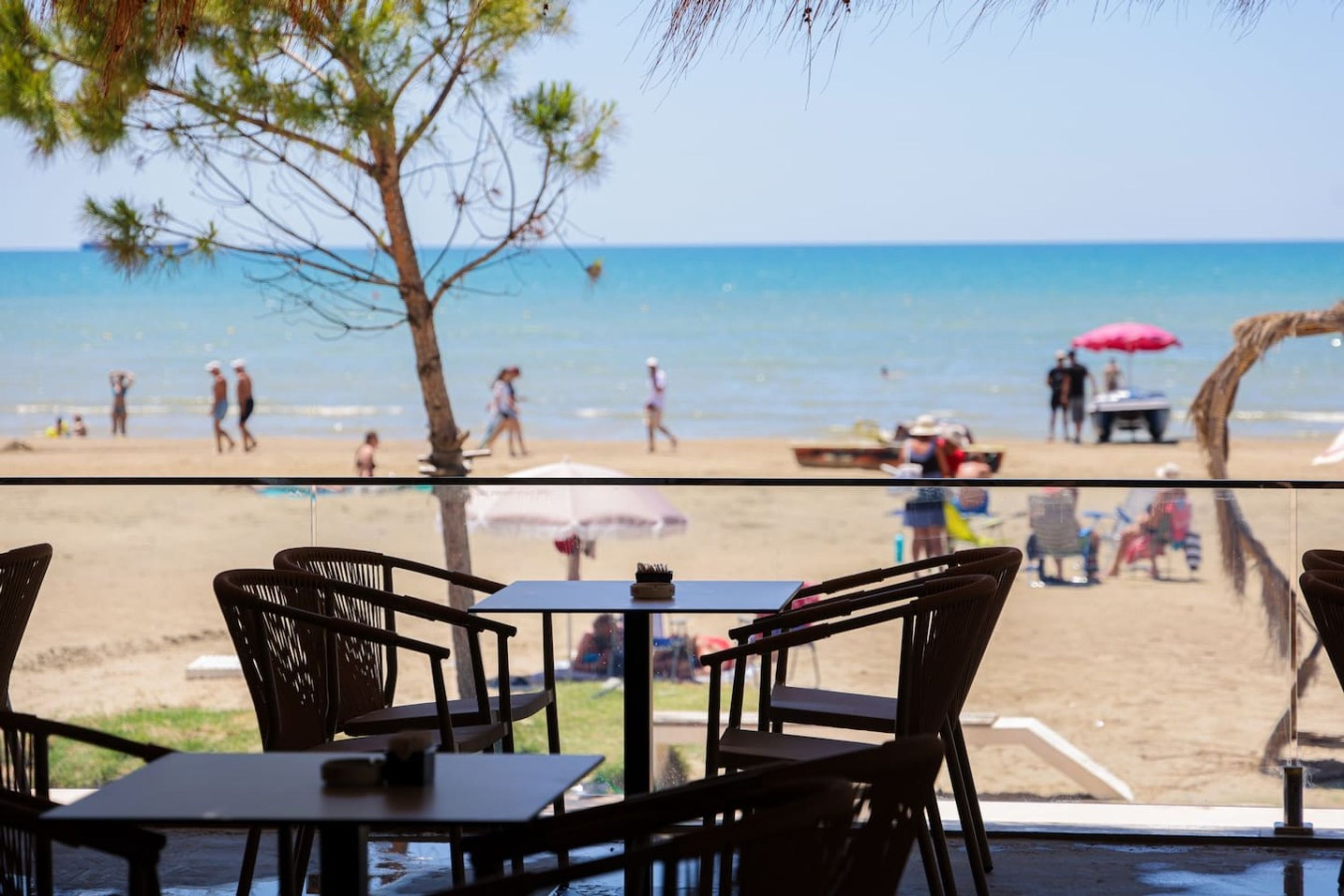 A beachside restaurant with outdoor seating overlooking the ocean.
