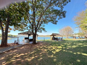 A lakeside park with picnic tables, a barbecue area, and a gazebo. - Pontal do Lago Flat Residence, Aproveite Dias Incriveis em Familia as Margens do Lago Corumba (Caldas Novas)