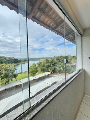 A balcony with a view of a lake and trees. - Pontal do Lago Flat Residence, Aproveite Dias Incriveis em Familia as Margens do Lago Corumba (Caldas Novas)