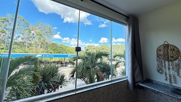 A room with a large window overlooking a marina and greenery.