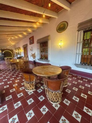 A dining area with a patterned floor, wooden tables, and chairs.
