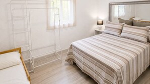 A bedroom with a bed, a bedside table, a lamp, a window with blinds, and a ceiling light fixture. - Casa Jimena con Piscina Privada (Torrox)