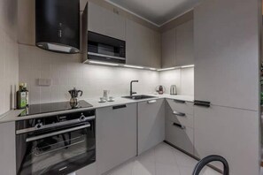 A modern kitchen with a built-in oven, a microwave, and a sink.