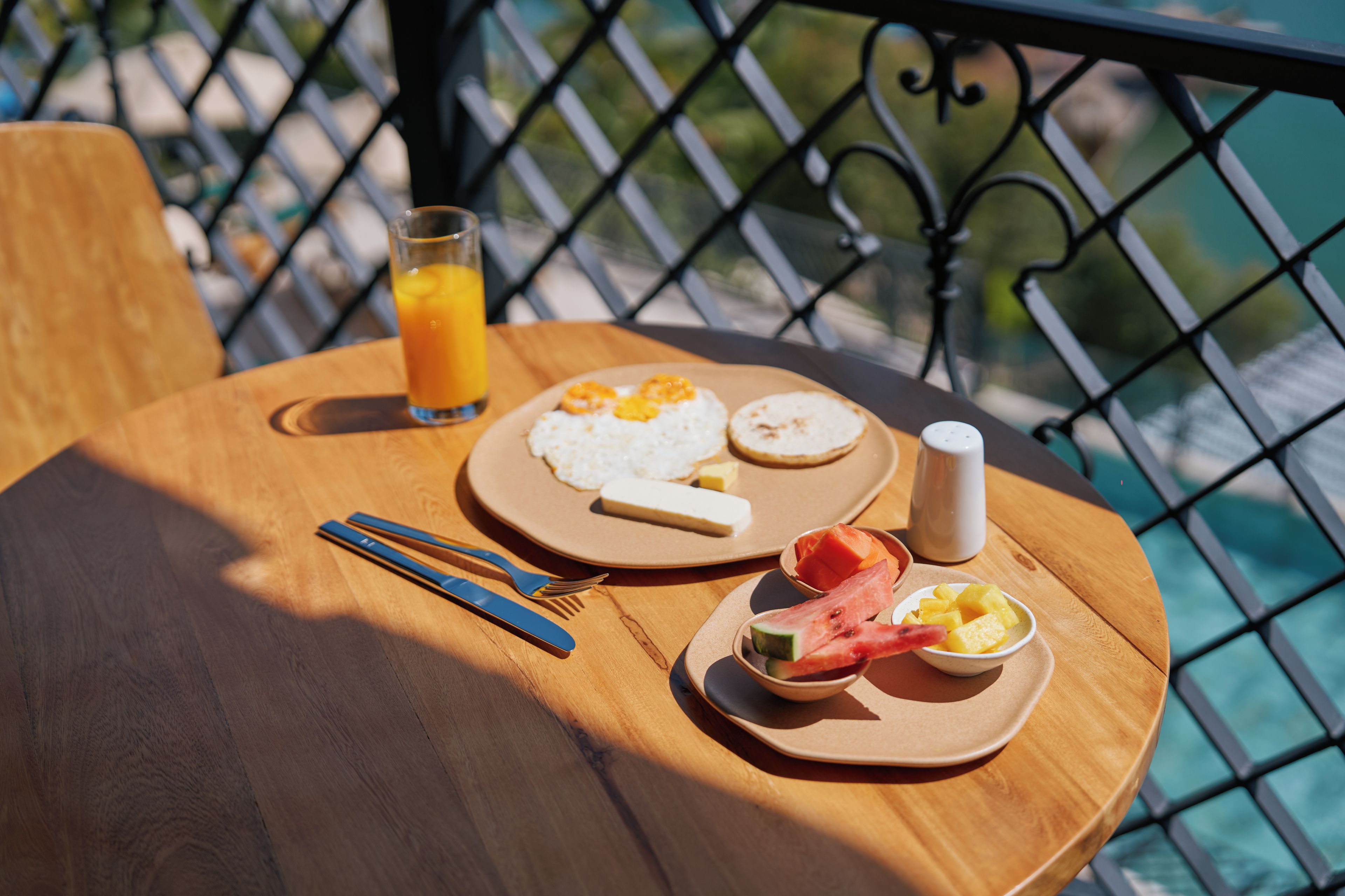 A table with breakfast items including eggs, toast, fruit, and a glass of orange juice.