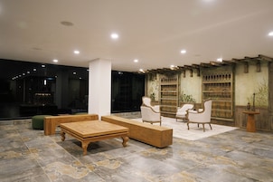 Un interior moderno con zona de estar, una mesa de centro de madera y una estantería con objetos decorativos.