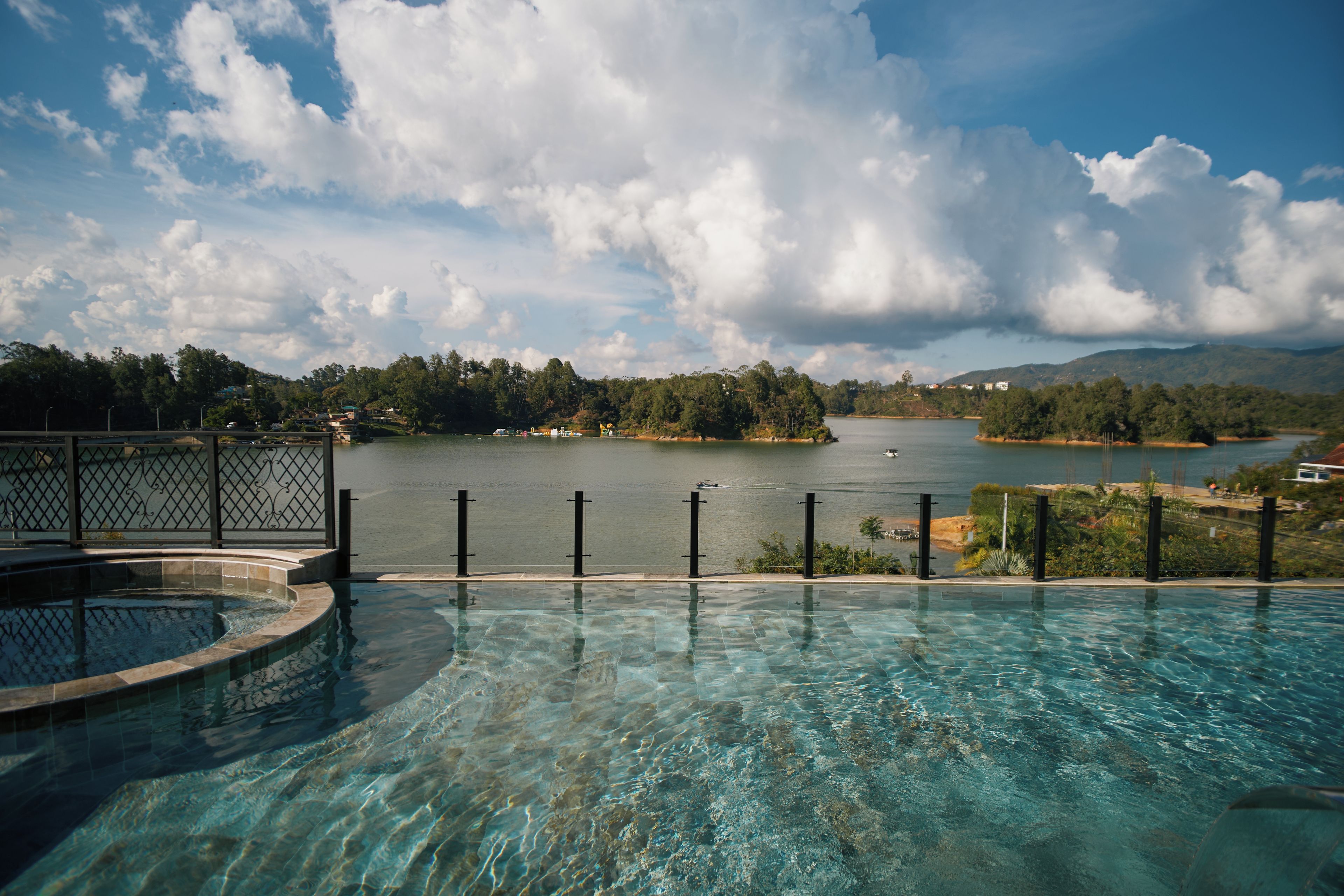 Une piscine aux eaux cristallines, offrant une vue sur un lac et les collines environnantes.