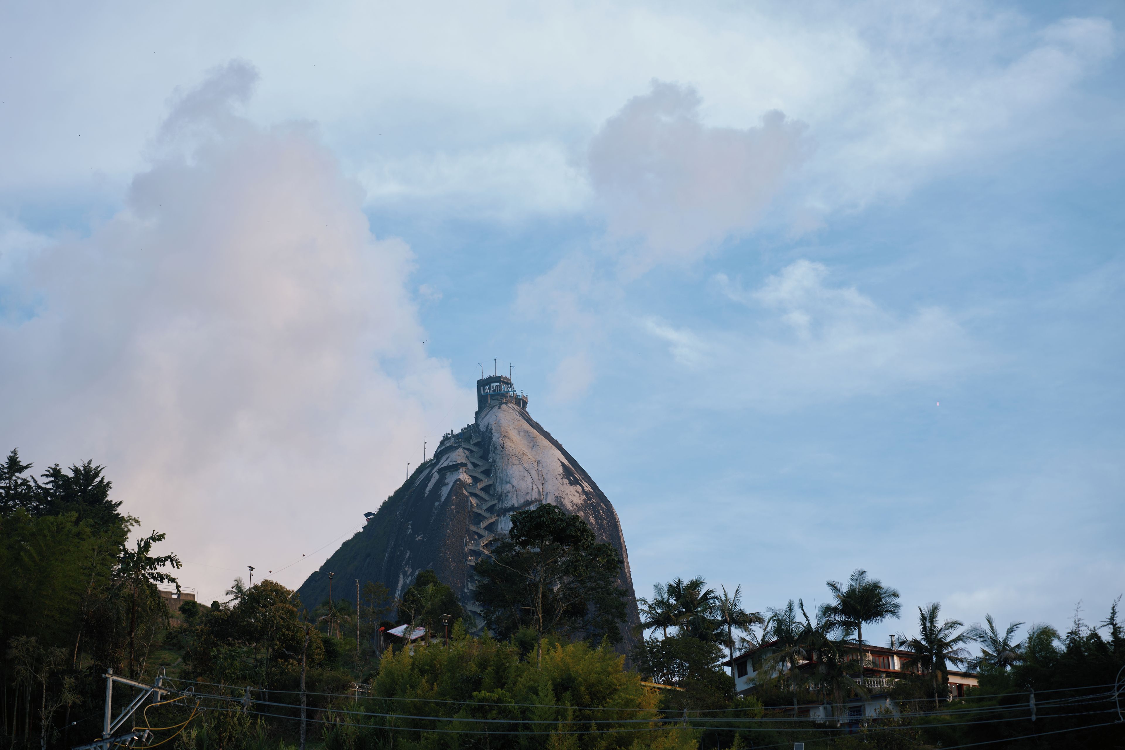 A mountain with a viewing platform and a building at its peak.