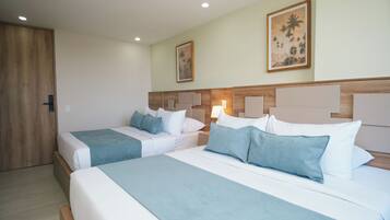 A hotel room with two beds, a wooden door, and a painting on the wall.