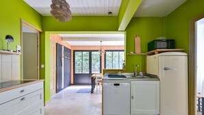 A compact kitchen with a dishwasher, a sink, and a microwave. - Les Muguets - Maison familiale à 5 min de la plage (Sainte Brevin-les-Pins)