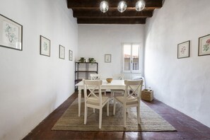 A dining area with a table and chairs, framed artwork on the walls, and a wooden ceiling. - Ruote Nest by MMega Homes and Villas  (Florence)