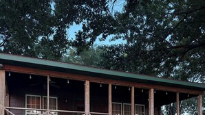 Eine Holzhütte mit Veranda, Treppe und einer Willkommensschild.