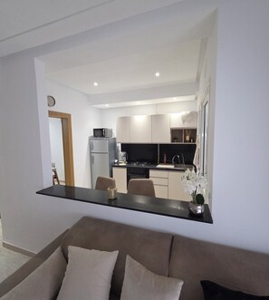 A modern living room with a sofa and a dining area with chairs.