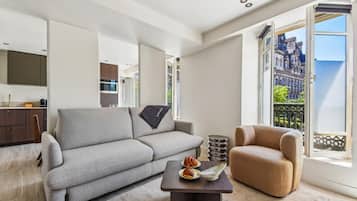 A modern living room with a grey sofa, a brown armchair, and a small table with a decorative item.