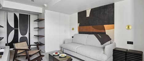Una sala de estar moderna con un sofá, sillones y una mesa de centro.