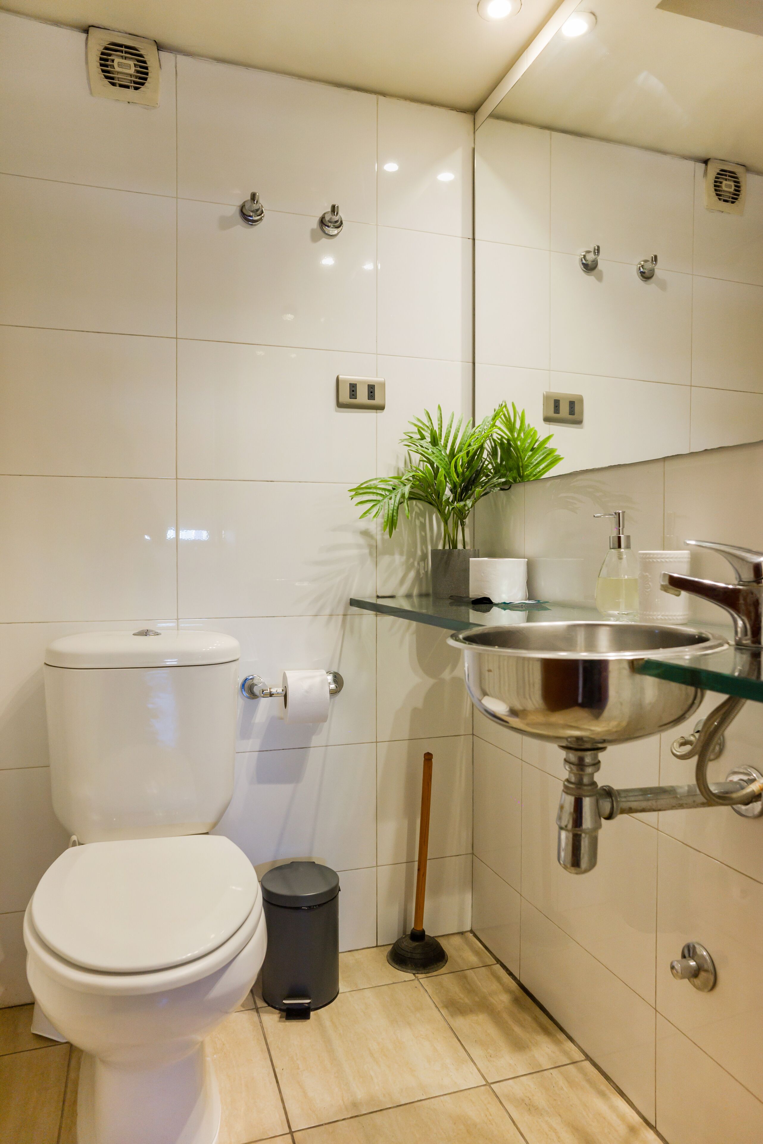 A modern bathroom with a toilet, sink, and mirror.
