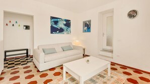 Un salon moderne avec un canapé, une table basse et un tapis à motifs.