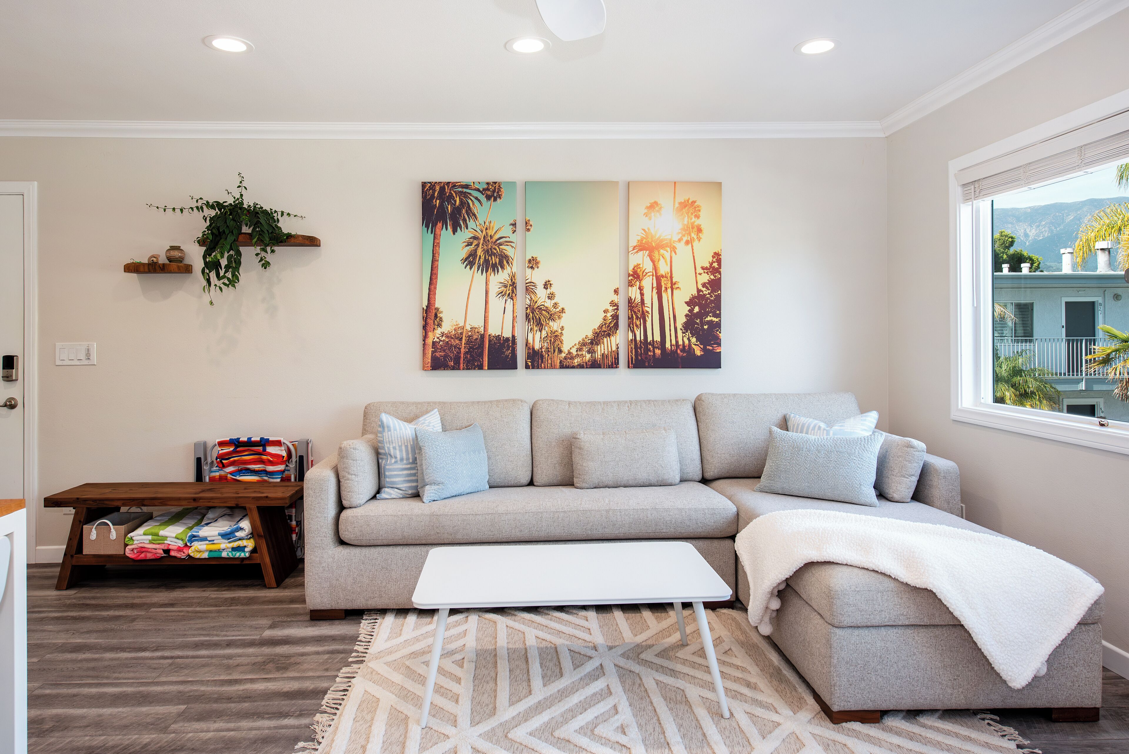 A living room with a sofa, coffee table, and artwork on the wall.