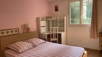 Une chambre à coucher avec un lit, un bureau et une fenêtre.