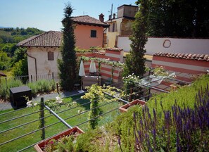 Una propiedad residencial con jardín, mobiliario exterior y vistas al paisaje circundante.