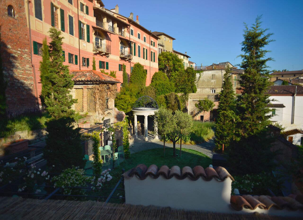A courtyard with a gazebo, a fountain, and a building with balconies.