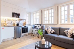 A modern living space with a kitchen, dining area, and seating area. - Historic Porto Studio Steps from Clérigos Tower (Porto)