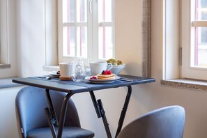 A dining area with a table set for breakfast, including pancakes, berries, and a cup. - Historic Porto Studio Steps from Clérigos Tower (Porto)