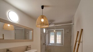 Een moderne badkamer met twee wastafels, een douche en een houten trap.