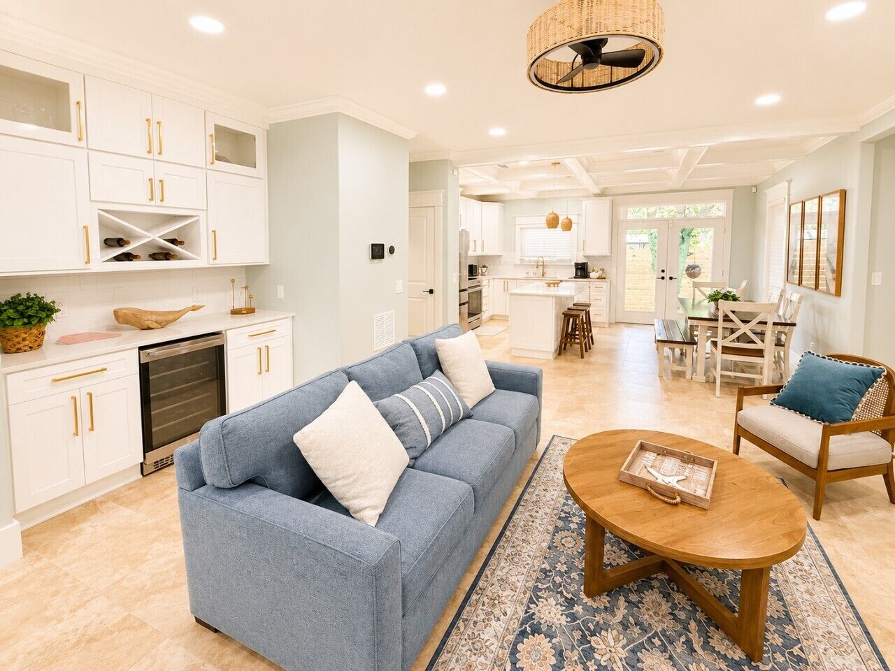 A modern living room with a sofa, coffee table, and a dining area with chairs.