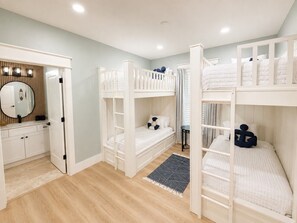 A room with bunk beds, a vanity with a mirror, and a small table. - Fully Renovated Beach Retreat in Sunnyside (Panama City Beach)