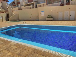 A swimming pool with a tiled edge, a metal ladder, and a tiled deck area. - Los Corales 1 - Four Bed Townhouse (Arona)
