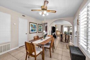 A dining area with a wooden table, chairs, and a ceiling fan. - Welcome to Mesquite Breeze, Your Relaxing Palm Springs Getaway (Palm Springs)