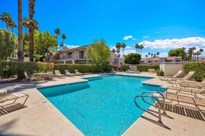 A swimming pool with lounge chairs and a building in the background. - Welcome to Mesquite Breeze, Your Relaxing Palm Springs Getaway (Palm Springs)